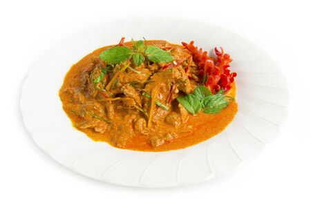 Dried red curry pork with coconut milk (Panang) Thaifood curry style topped with bergamot leaf slice and chili side view isolated on white backgroundの写真素材