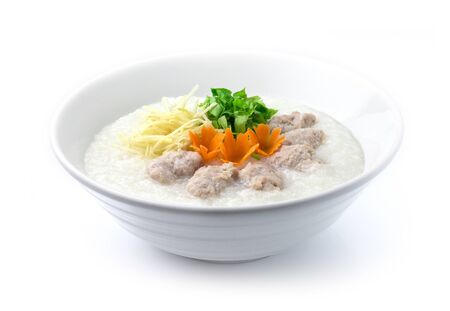 Congee Pork Rice Porridge served slice ginger and cutlet Celery. Asian Food breakfast decorate with carved carrots side viewの写真素材