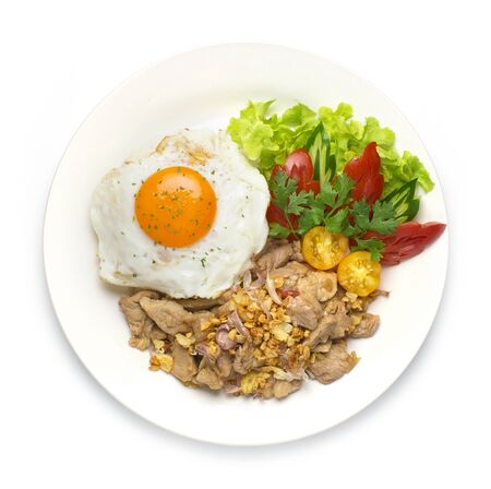 Thai food Fried Pork with Garlic and Thai peppers and Rice on top with Fried egg decorate with carved tomato and cucumber style The best popular Thai Street food goodtasty top viewの写真素材