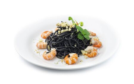Black Spaghetti Stir Fried with Shrimps and chopped Garlic Thai Food Mixed Italian Fusion style decorate with carved spring onions and leaf mint side viewの写真素材