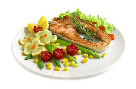 Roasted Salmon steak fusion food with asparagus,lemon, grill tomato and carved vegetables style side viewの写真素材