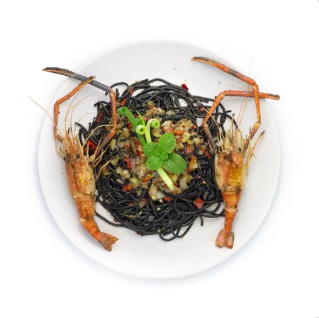 Black Spaghetti Spicy Food Served with Grilled Shrimps Thai Food Mixed Italian Fusion style decorate with carved chili and spring onions top viewの写真素材