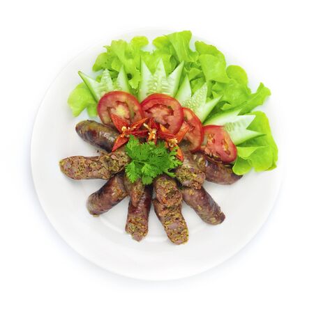 Pork Sausage Spicy tasty in Northern Food of Thailand Style decorate with vegetables carved Cucumber, chili and coriander Thai herbs top viewの写真素材