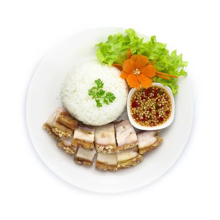 Crispy Pork with Rice (Crispy Belly Pork) Served with Chili Sauce. Asian Food dish Decorate vegetables and carved carrot top viewの写真素材