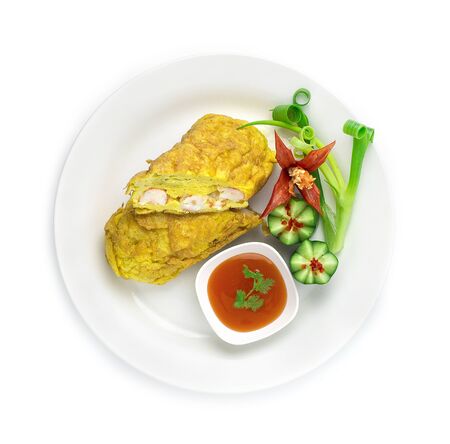 Omelette with Shrimps (Fried Eggs Stuffed with Shrimps Thai Style) Thai Food Maincorse served Chilli Sauce Decorate carved Cucumber and Spring Onion top viewの写真素材