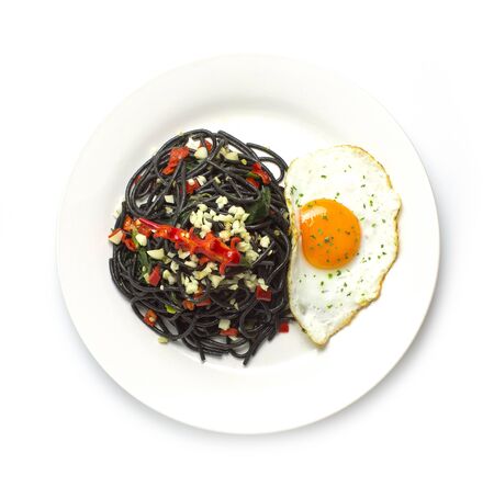 Spaghetti stir fried with Thai Basil spicy sauce and Fried egg fusion Thai style on top carved chili top viewの写真素材