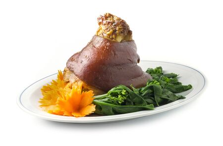 Stewed Pork Leg boiled in Sweet Brown Sauce Chinese Herbs Style decorate with carved vegetables and Chinese kale side viewの写真素材