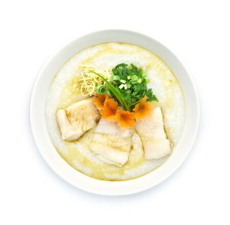 Congee Fish Asian Seabass ,Rice Porridge served slice ginger and cutlet Celery,coriander thai herb. Asian Food breakfast decorate with carved carrots and spring onion top viewの写真素材