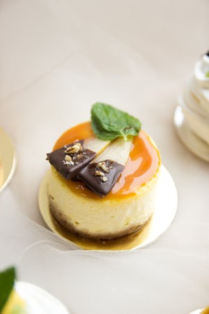 This stock photo shows a mini cheesecake decorated with slices of pear and mint leaf.の写真素材