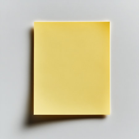 A bright yellow sticky note on a clean white surface awaits your ideas.の素材