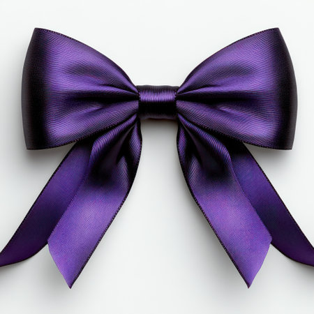 Rich purple satin bow rests on a smooth white surface, ideal for gift wrapping or decor.の素材
