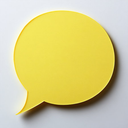 A bright yellow speech bubble sits on a white surface, inviting conversation.の素材