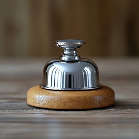 A shiny welcome bell sits on a smooth wooden base, nestled in a warm and inviting space.の素材