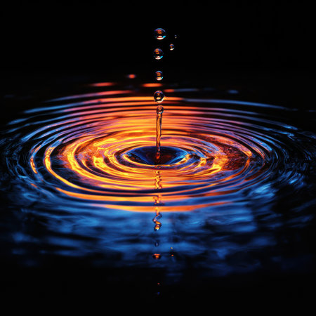 Droplets create ripples in dark water, blending colors in a stunning night scene.の素材