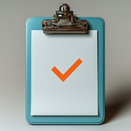 A clipboard holds a checklist with an orange checkmark, representing completed tasks.の素材