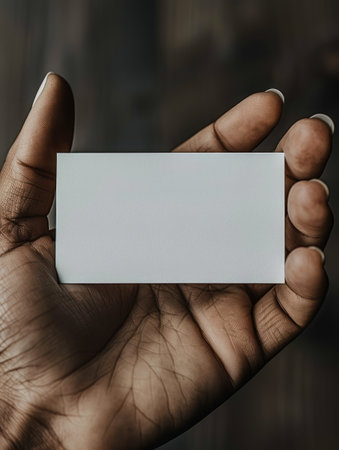 A hand holds a blank white card, ready for your message.の素材