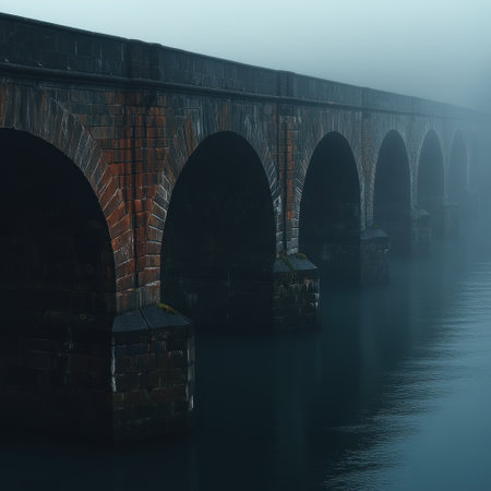 Ancient stone bridge rises from fog, creating an enigmatic scene over still waters.の素材