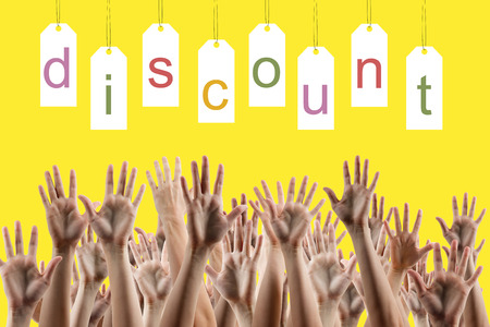 Discount word on labels over yellow gradient background, people's hands lifted up in the air.. Sale poster. Festive backdrop poster on Black Friday theme with copy space and clipping passの写真素材