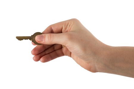 Close up view of hand holding key to a dream house isolated on white. Clipping pass and copy space. REAL ESTATEの写真素材