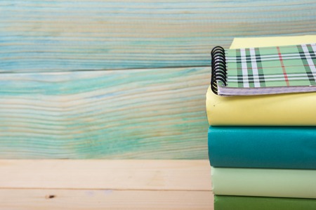 Back to school. Stack of colorful books on wooden table. Composition with vintage old hardback...