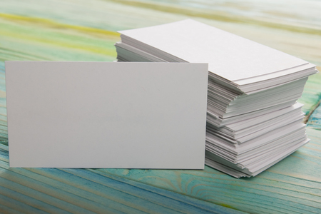 White blank business visit card, gift, ticket, pass, present close up on blurred blue background. Blank corporate identity package business card. Template for IDの写真素材