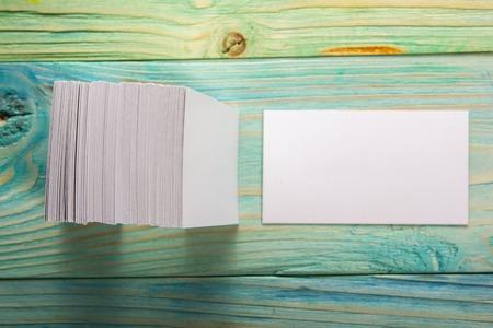 White blank business visit card, gift, ticket, pass, present close up on blurred blue background....