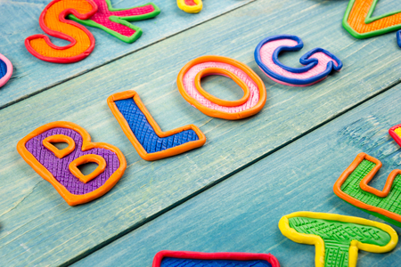 Word BLOG made with plasticine letters on old wooden blue board backgroundの写真素材