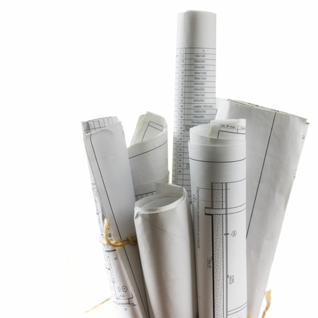 Architectural blueprints and blueprint rolls on white backgroundの写真素材