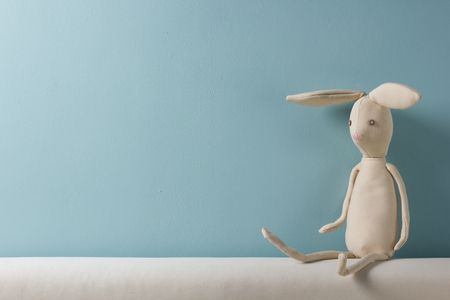 Home interior. Childhood. Blue background. Toy sitting on a couch. Copy spaceの写真素材