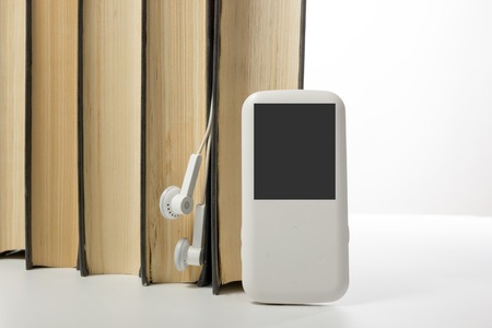 Audio book Stack of hardback books and electronic reader. Electronic library concept. Back to school. Copy space.の写真素材
