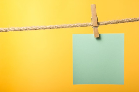 Blank paper notes hanging on rope with clothes pins, copy space for text or image or product...