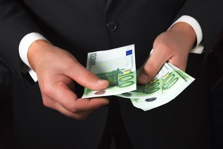 Businessman's hands counting money euro banknotes in the pocket.の写真素材
