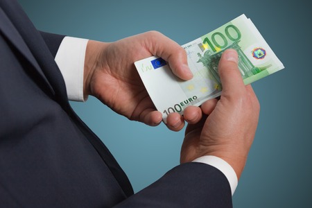 Businessman's hands counting money euro banknotes in the pocket.の写真素材