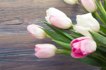 Beautiful pink flowers tulips on wooden table. Top view with copy space. Toned pictureの写真素材