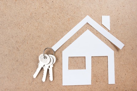Silver key with house figure and on wooden background. Real Estate Concept. Top viewの写真素材