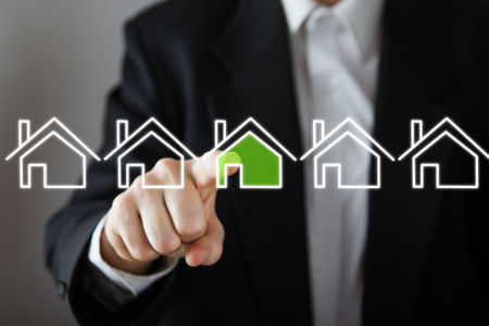 Businessman choosing house, real estate concept. Hand pressing the house icon. Copy space.の写真素材