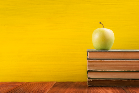 Colorful composition with vintage old hardback books, diary on wooden deck table and yellow background. Books stacking. Back to school. Copy Space. Education backgroundの写真素材
