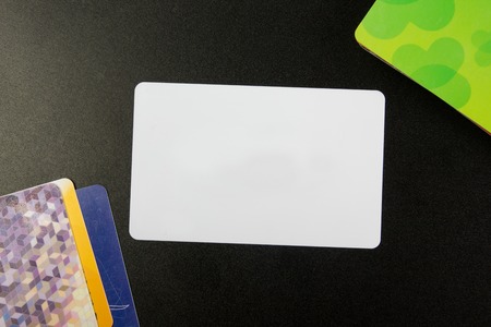 White blank business card. Office table desk with set of colorful supplies, cup, pen, pencils,...