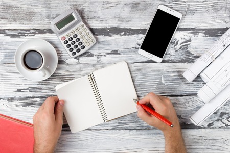Office table desk with set of colorful supplies, white blank note pad, cup, pen, pc, crumpled paper,...