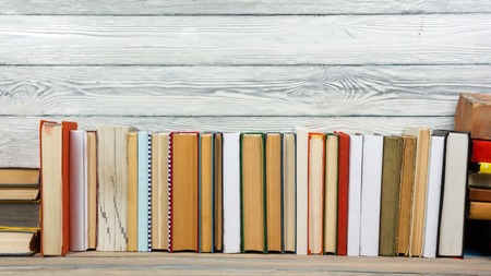 Colorful composition with vintage old hardback books, diary on wooden deck table and wood background. Books stacking. Back to school. Copy Space. Education backgroundの写真素材