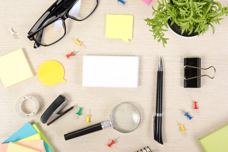 White blank business card. Office table desk with set of colorful supplies, cup, pen, pencils,...