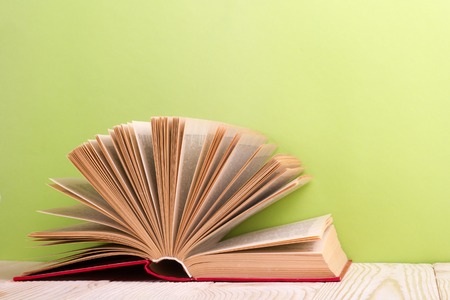 Open book on green wooden background. Education concept. Copy space for ad.の写真素材