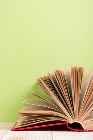 Open book on green wooden background. Education concept. Copy space for ad.の写真素材
