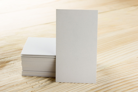 White blank business visit card, gift, ticket, pass, present close up on wooden background. Copy space Blank corporate identity package business card Template for IDの写真素材