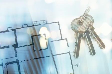 model of a house and key ring on a blueprintの写真素材