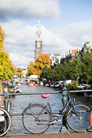 Amsterdam Holland Netherlands houses, blooming flowers, and bicycles near famous  canals Singel with typical dutch houseboatsの写真素材