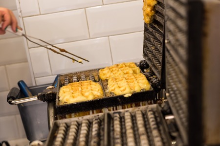 Cooking Belgian waffles in bakery - food background. Gaufres au sucreの写真素材
