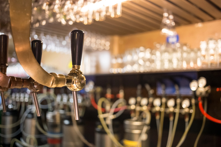 Frosty glass of light beer on the bar counter. Beer tapの写真素材