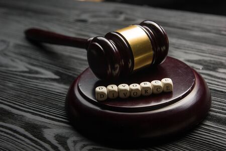 Divorce and separation concept. Two golden wedding rings, judge gavel.の写真素材