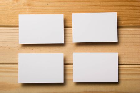 Business card blank on wooden background. Corporate Stationery, Branding Mock-up. Creative designer desk. Flat lay. Copy space for textの写真素材
